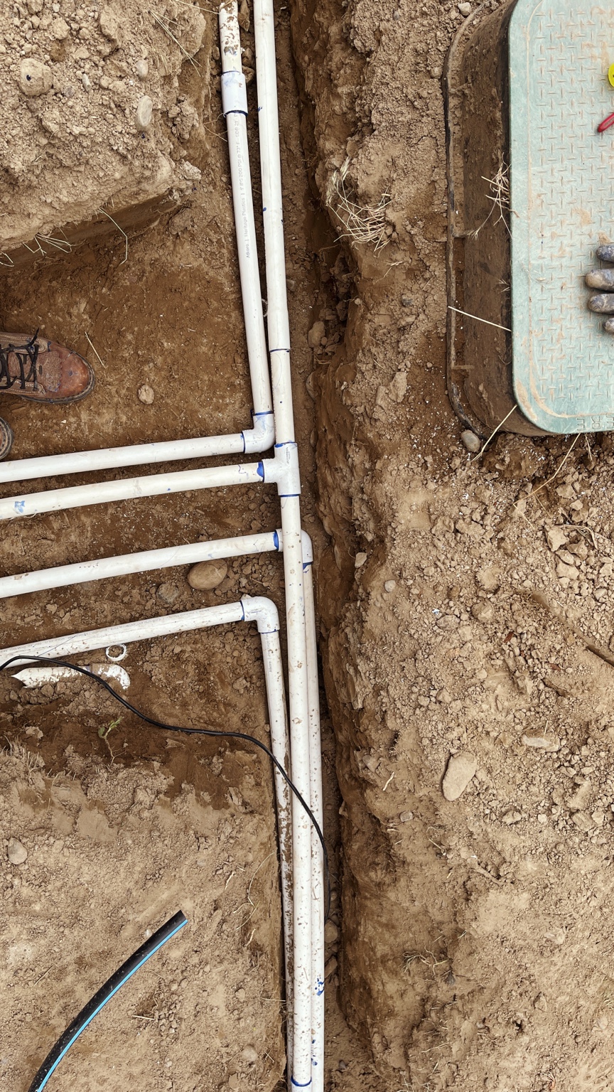 Complex PVC mainline grid running through a deep pit next to a valve box in Burbank