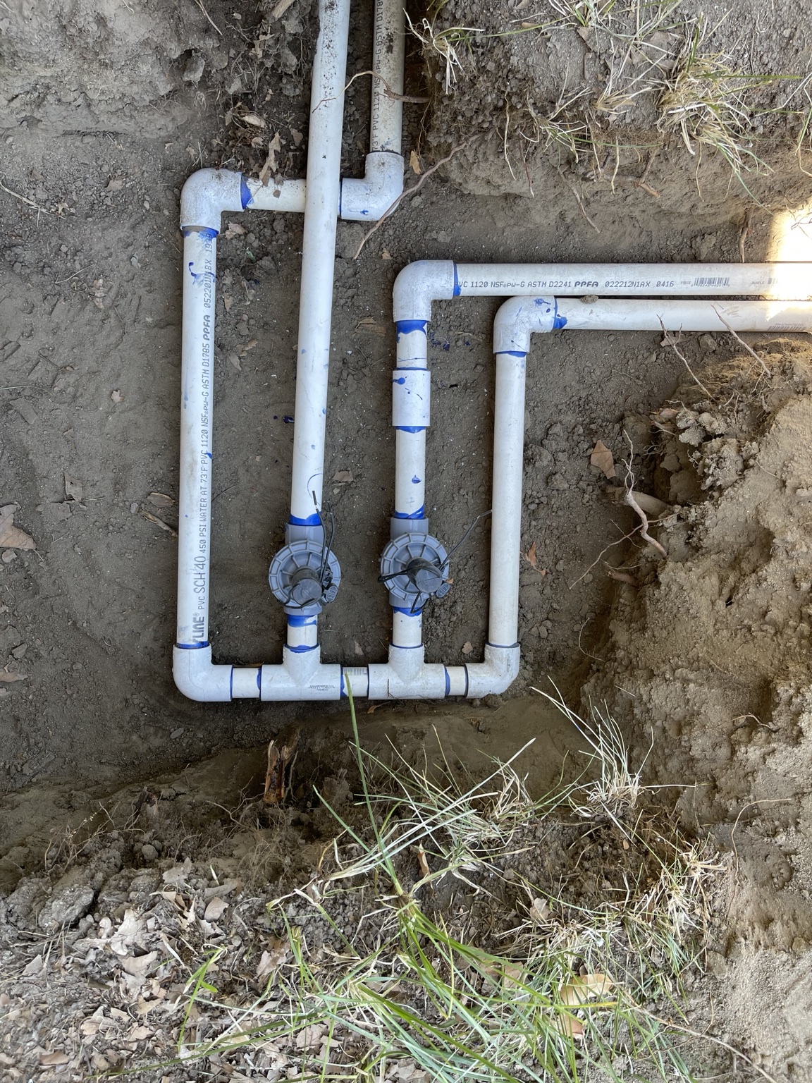 Two-valve PVC manifold plumbed into a lateral run in a Finley trench