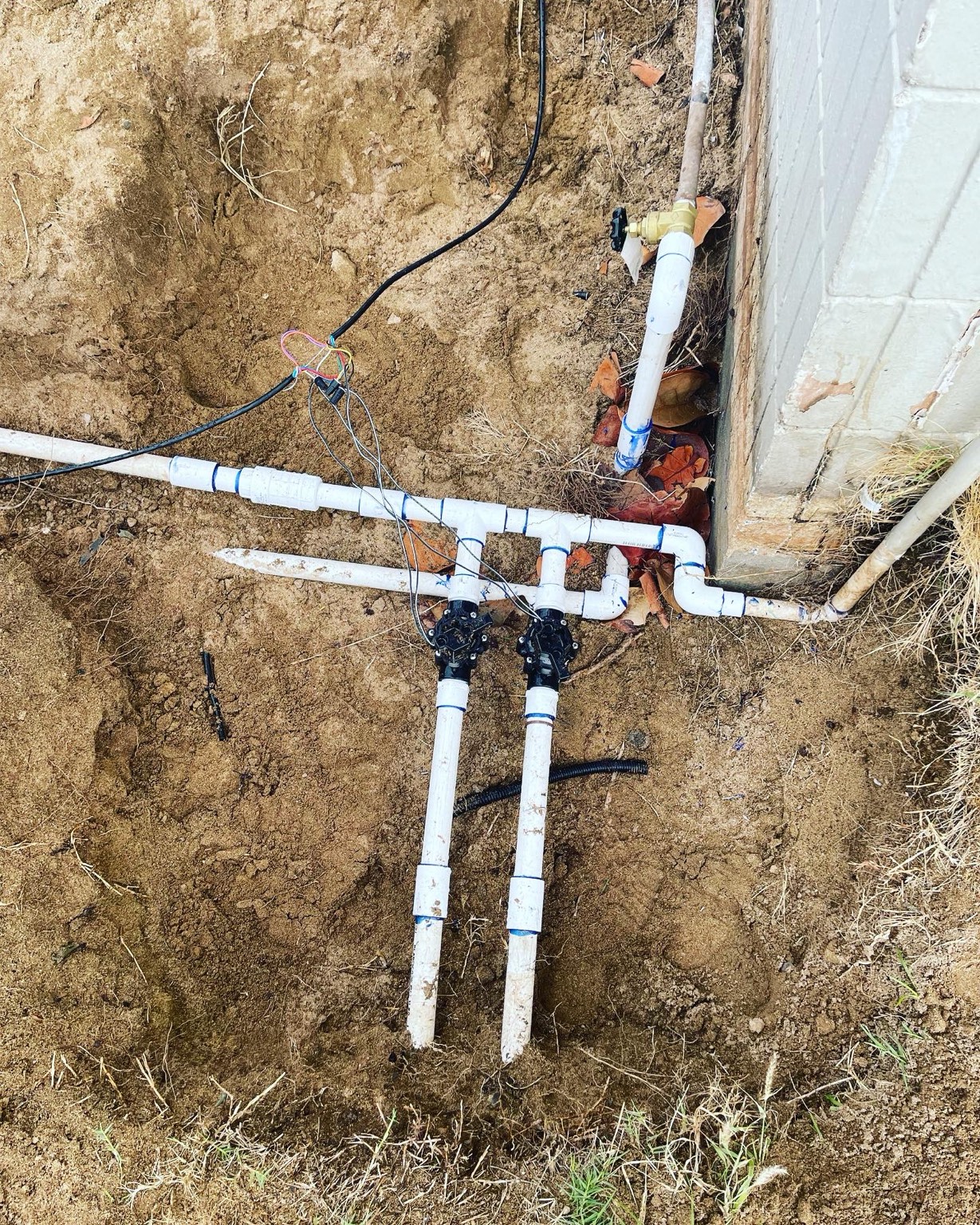 New PVC valve manifold set against a foundation in Kennewick