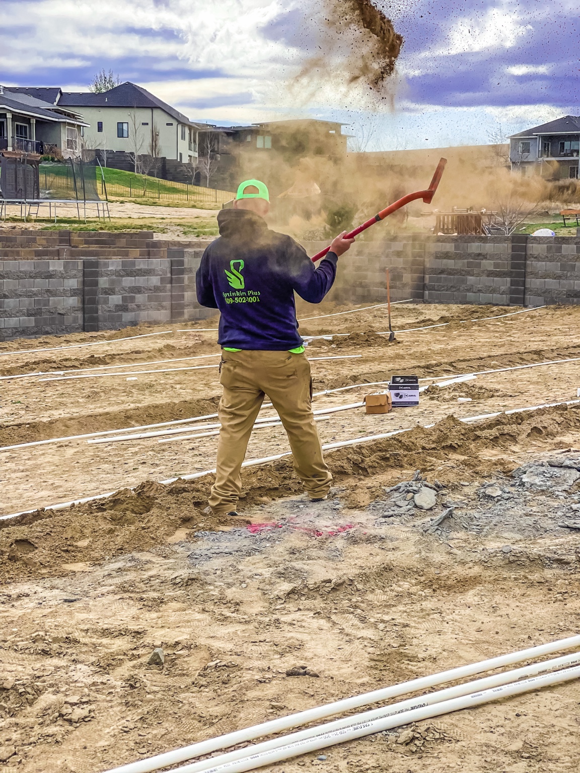 Sprinkler Plus tech launching a shovel of dirt on a new install site in Richland