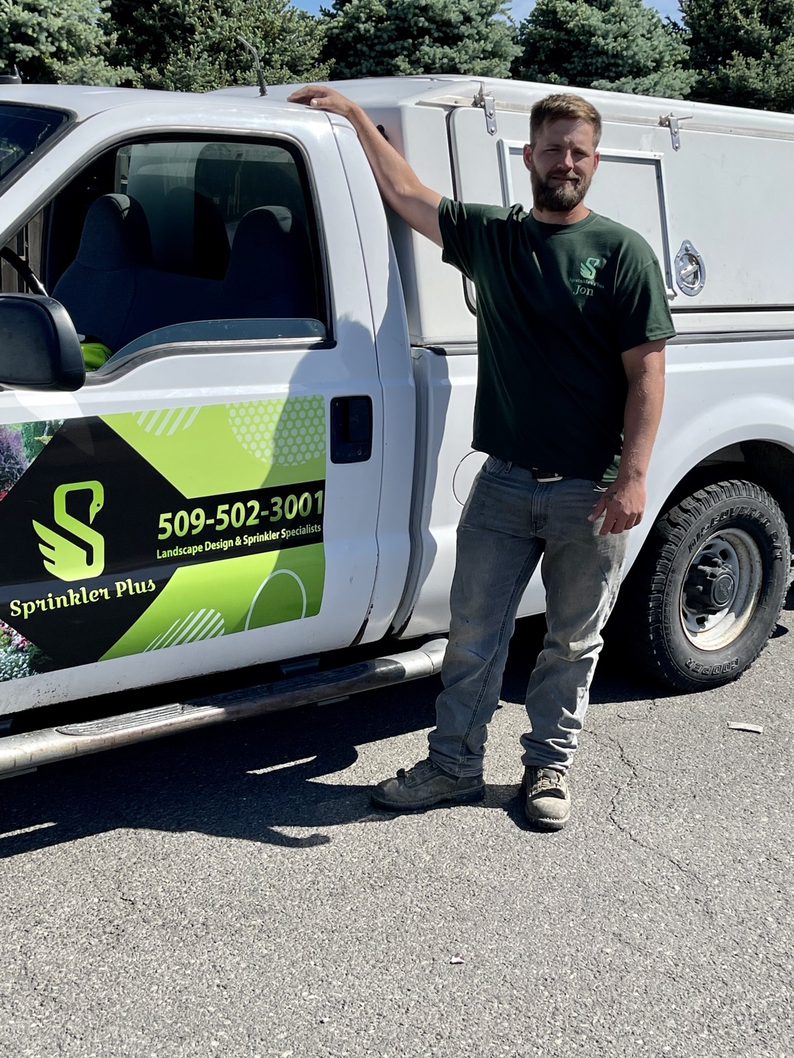 Sprinkler Plus technician Jon posing next to a wrapped service truck in Richland